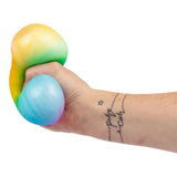 Hand squeezing the large rainbow dumpling alongside a blue mini dumpling squishy toy