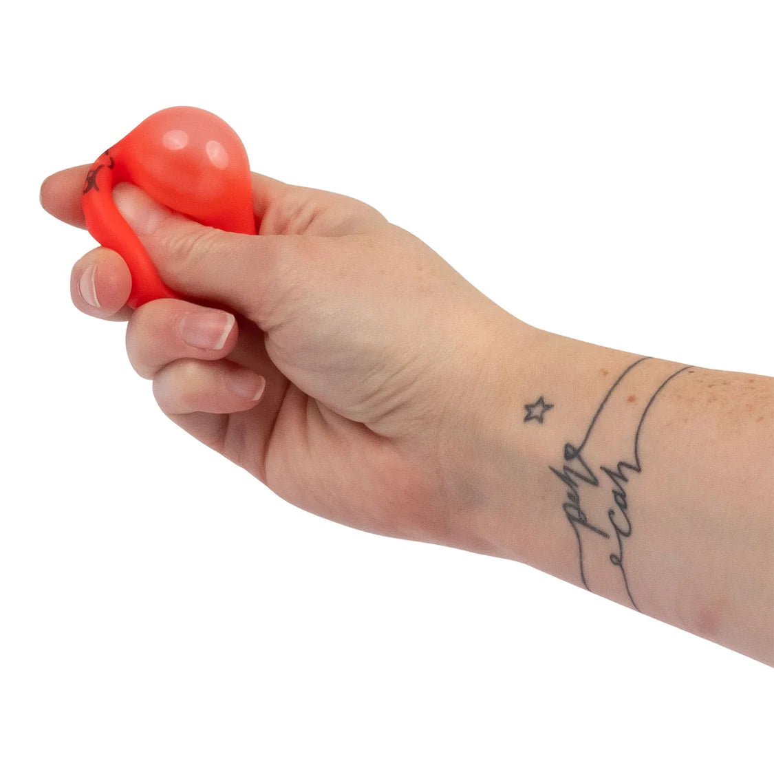 Hand squeezing a coral red mini kawaii dumpling squishy toy from the Mega Rainbow set