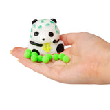 White squishy panda with bamboo leaf print and neon green sticky pom-pom balls displayed on an open palm