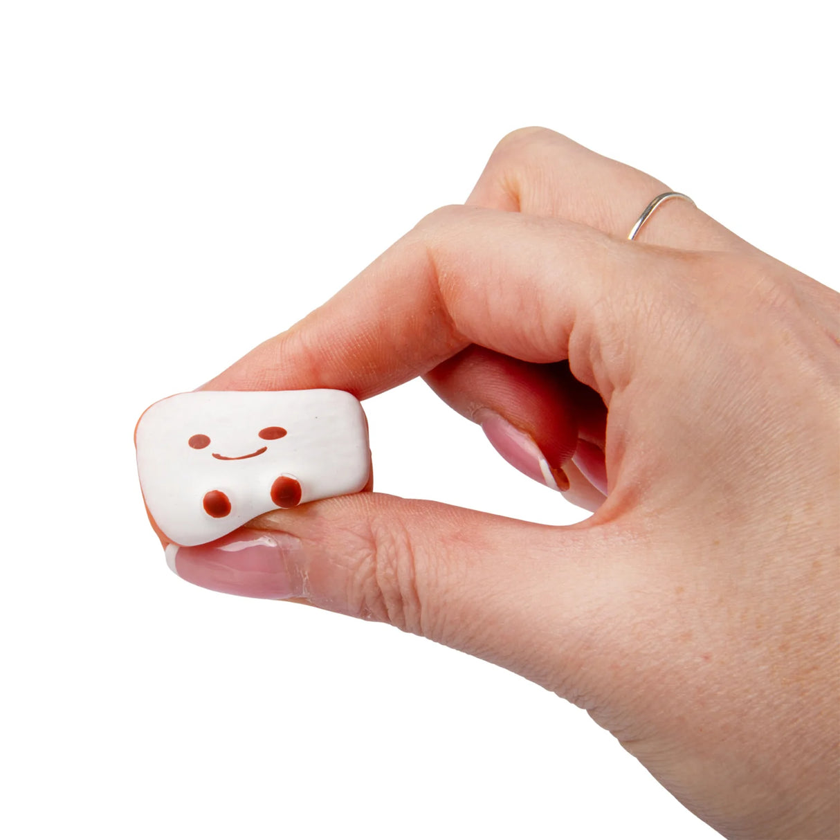 Hand pinching a soft white bread roll kawaii squishy fidget toy from the Bakery set