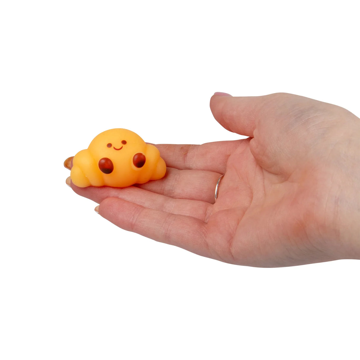 Hand holding a small yellow bun kawaii squishy fidget toy from the Bakery set