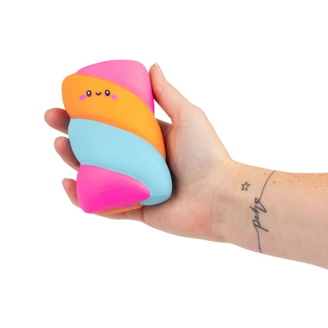 Tattooed hand holding a pink, orange and blue squishy marshmallow fidget toy