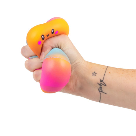 Tattooed hand squeezing a squishy marshmallow toy showing the slow-rise foam deforming