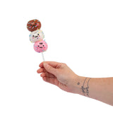 Hand holding Scrunchems Sticky Squishy Cake Pop with chocolate, vanilla and pink kawaii faces