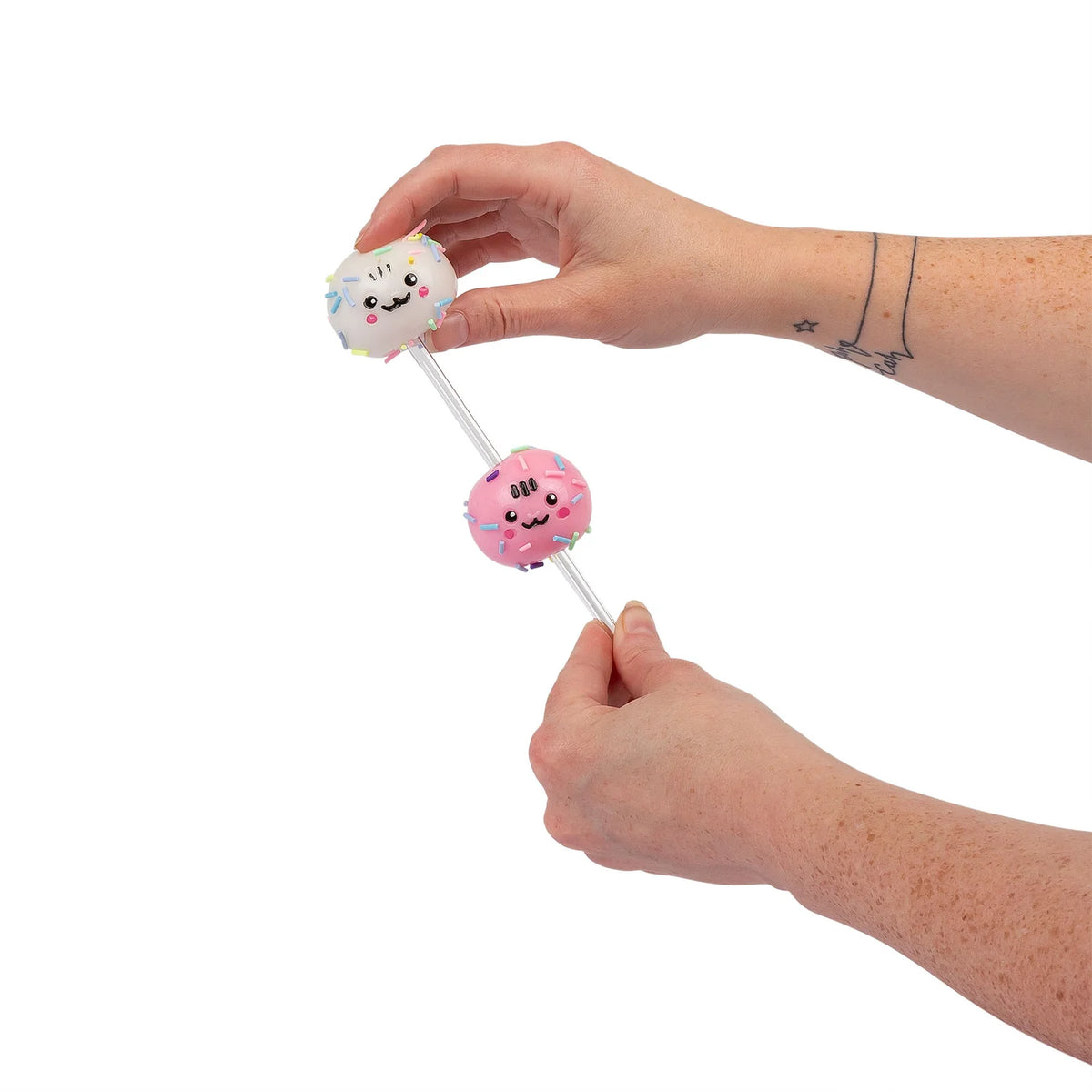 Hands sliding vanilla and pink sticky squishy balls onto Scrunchems Cake Pop stick
