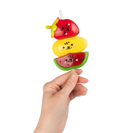 Hand holding Scrunchems Sticky Squishy Fruit Stack tanghulu skewer with kawaii fruit faces