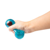 Hand squeezing and deforming a teal blue glitter Scrunchems Sugar Capybara squishy