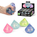 Hand squeezing a purple Scrunchems Sugar Diamond alongside all four colour variants and retail display box