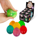 Display box of Scrunchems Sugar Dragon Eggs with hand squeezing green egg and six colours shown