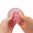 Hands squeezing pink Scrunchems Sugar Dragon Egg showing soft squishy dragon scale shell