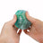 Hands squeezing teal Scrunchems Sugar Dragon Egg showing translucent scale texture