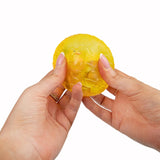 Hands squeezing yellow Scrunchems Sugar Dragon Egg showing soft squishy texture