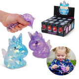 Blue and purple glitter Scrunchems Sugar Unicorn squishies shown with hand squeezing one and retail display box