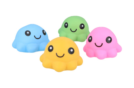 Four kawaii-style squishy octopus squeeze toys in blue, yellow, green, and pink, each with a smiling face, arranged in a loose cluster against a white background