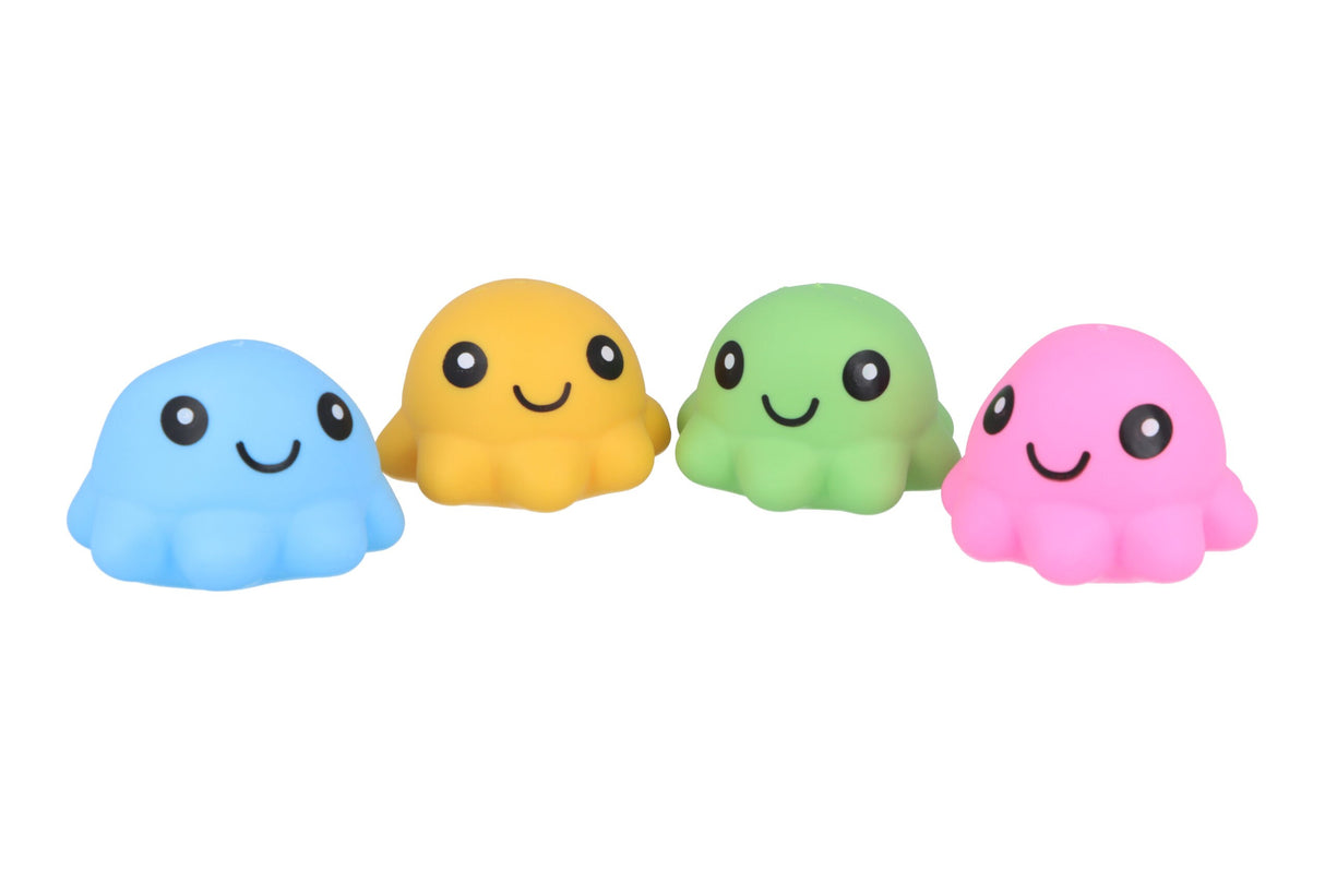 Four kawaii-style squishy octopus squeeze toys in blue, yellow, green, and pink lined up in a row, each with a smiling face, against a white background