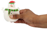 Hand squeezing pop-up snowman squishy toy with red santa hat and green scarf