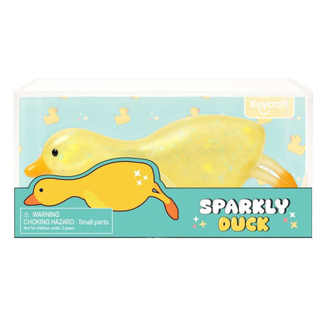 Yellow glitter squishy duck toy shown in clear Keycraft branded packaging with duck-print background