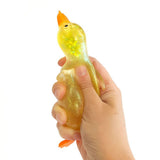 Top-down view of a yellow iridescent glitter squishy duck with orange beak and feet