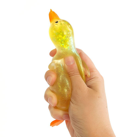 Top-down view of a yellow iridescent glitter squishy duck with orange beak and feet