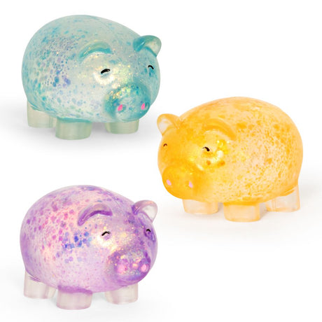 Three glitter squishy pig toys in blue, yellow, and purple, shown side by side on a white background