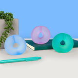 Lilac, blue and teal Speks Gump Loop memory gel fidget rings on a desk