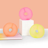 Pink, peach and lime Speks Gump Loop memory gel fidget rings displayed on a desk