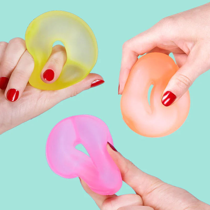 Hands squeezing pink, peach and lime Speks Gump Loop squishy fidget toy rings
