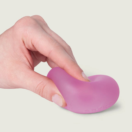 Hand squeezing and bending a pink Moon Jelly Speks Gump Original memory gel stress ball