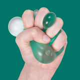 Fist squeezing a teal Sea Glass Speks Gump Original memory gel stress ball, gel bulging between fingers