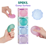 Four Speks Gump Surface memory gel stress balls in pink, teal, blue and purple, shown with packaging on a transparent background