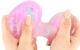 Two hands squeezing a pink glitter Squeeze Pops Axolotl toy, showing the iridescent confetti and figure transferring between spheres