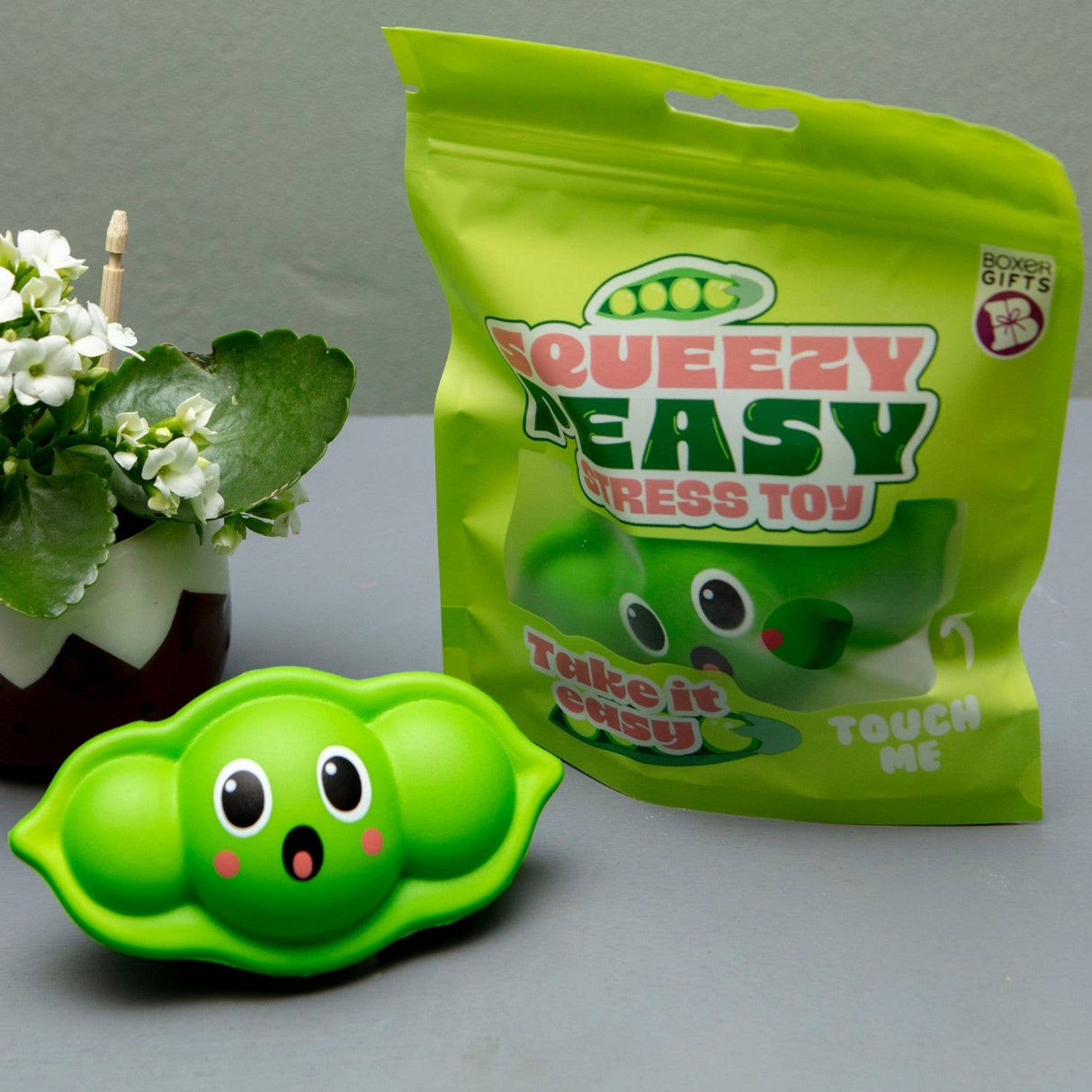 Kawaii pea pod squishy stress toy next to its bright green Squeezy Peasy resealable bag