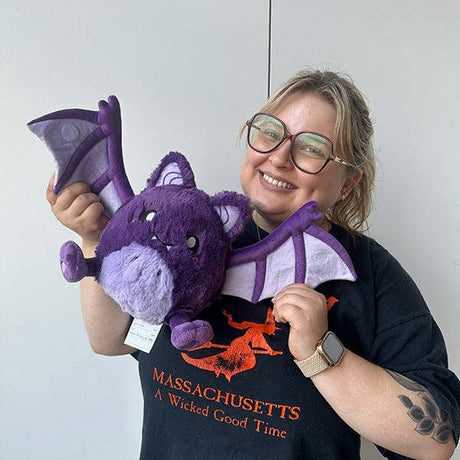 Squishable Mini Spooky Bat purple plush held by person lifestyle shot