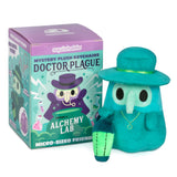Teal plush keychain with top hat next to its packaging on a white background