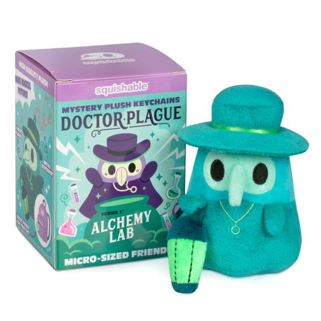 Teal plush keychain with top hat next to its packaging on a white background