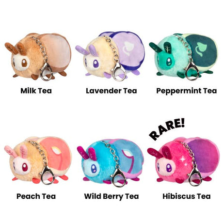 Set of colorful tea-themed plush keychains with labels on a white background