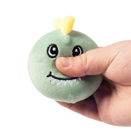 Hand squeezing green squishy dinosaur plush sensory toy demonstrating soft sugar-filled texture