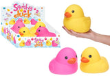 Yellow squishy duck held in hand showing size, with pink and yellow squishy ducks and retail display box