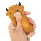 Hand squeezing dark brown Squishy Highland Cow showing slow rise stress relief sensory fidget toy texture