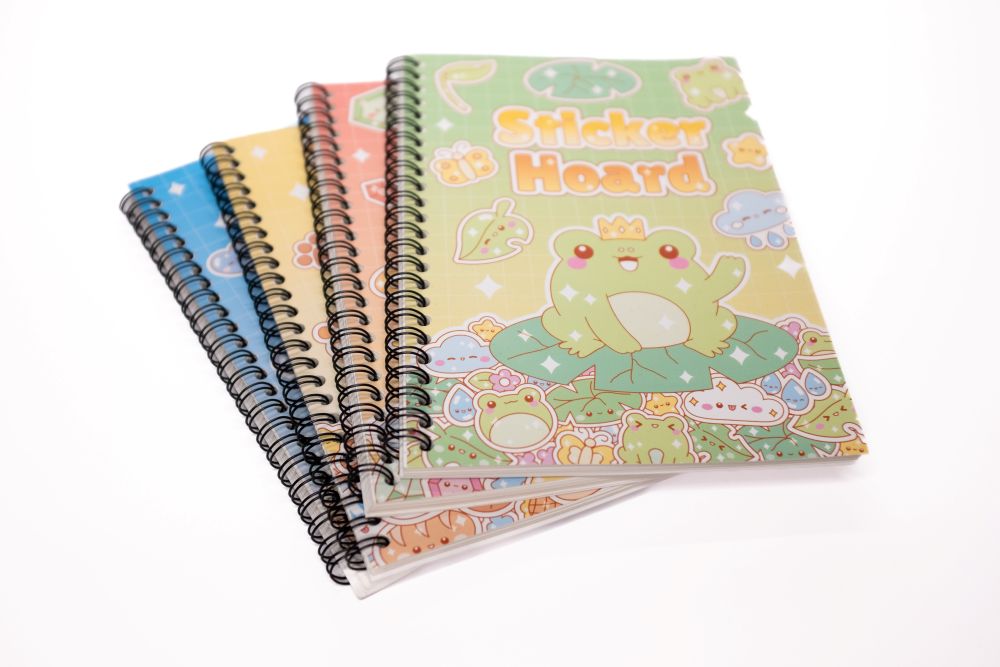 Four Sticker Hoard sticker books fanned with green frog cover design on top