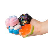 Four Scrunchems Sticky Squishy Paw Print designs being held in a hand showing size and variety