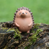 Stress Hog kawaii hedgehog squishy standing upright on a mossy log outdoors