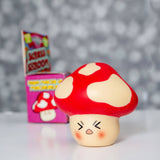 Stress Shroom kawaii red mushroom squishy displayed out of its box against a bokeh background