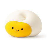Kawaii egg Stretch N Smash fidget toy shown squashed flat, displaying the stretched shape of the white outer
