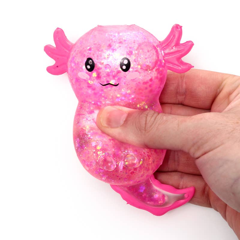 Hand squeezing a pink glitter axolotl squishy sensory fidget toy for stress relief