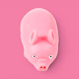 Pink Stretchies Pig sand-filled squishy toy photographed from above on a pink background