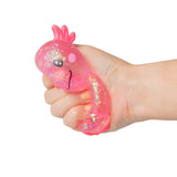 Hand squeezing a pink large Sugar Axolotl squishy showing iridescent glitter shifting inside