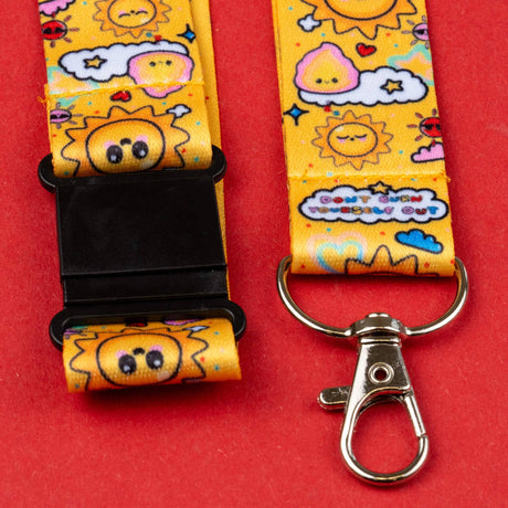 Lanyard with cartoon sun and cloud design on a red background