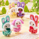 Five Sylvanian Families bunny costume baby figures displayed together in a garden scene