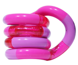 Pink and lilac Tangle Classic fidget toy coiled into its resting spiral shape with glitter segment detail